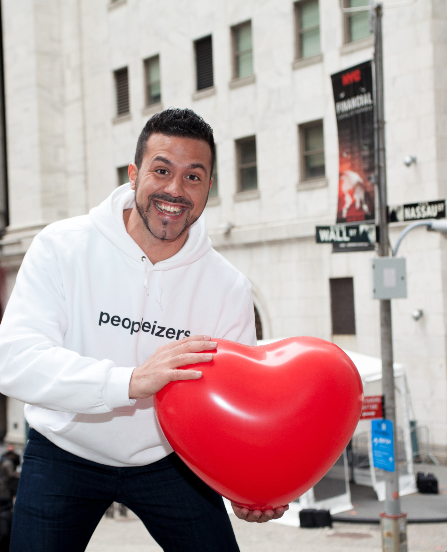 Lefti with a red heart balloon in front of Wall Street
